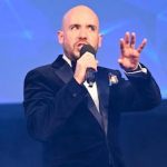 Tom Allen speaking on stage.