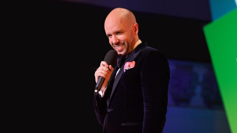 Tom Allen speaking on a stage.