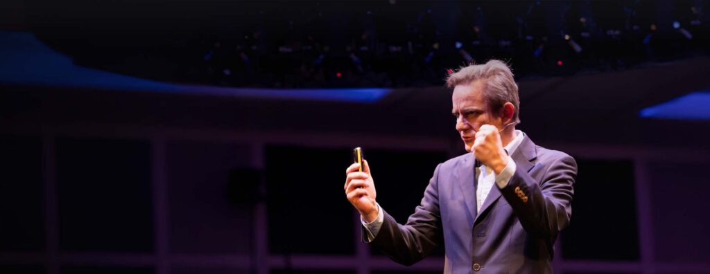 Robert Guest speaking on a stage.
