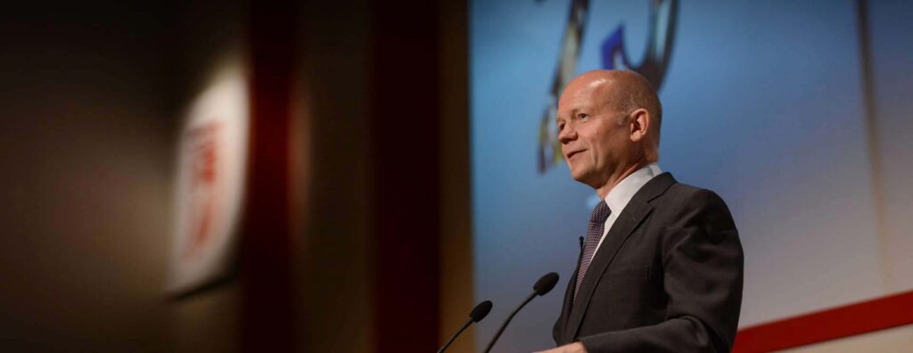 William Hague speaking on stage.