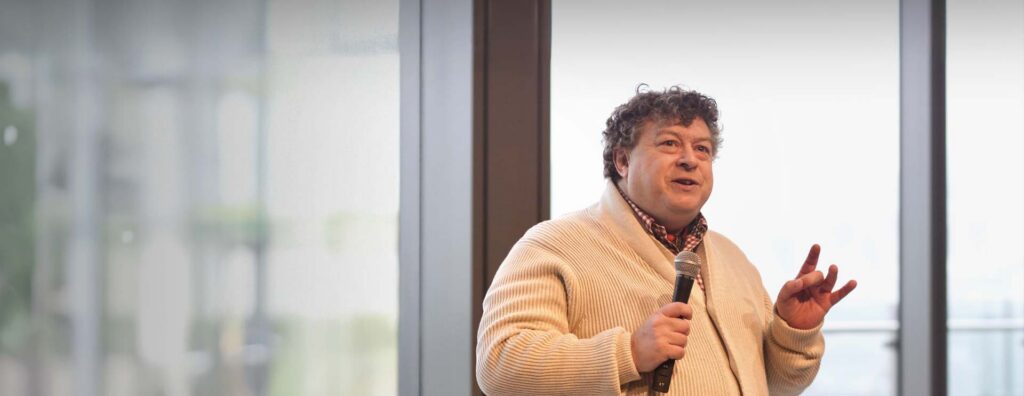 Rory Sutherland speaking on a stage.