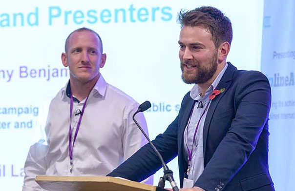 Jonny Benjamin & Neil Laybourn speaking on stage.