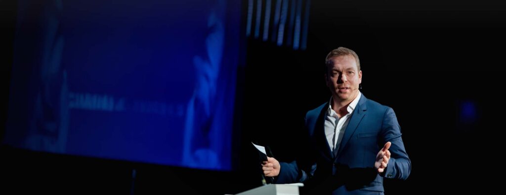 Chris Hoy speaking on a stage.