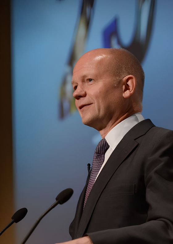 William Hague speaking on a stage.